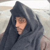 a man wearing sunglasses and a scarf around his neck