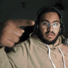 a man wearing headphones and glasses is pointing