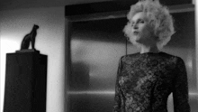 a black and white photo of a woman in a black lace dress