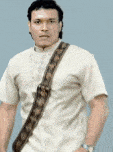 a man in a white shirt with a brown strap around his neck