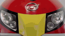 a close up of the front of a red car with a silver g on the hood