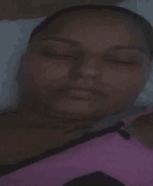 a woman is sleeping in a bed with her eyes closed