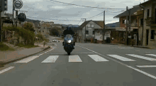 a man is riding a motorcycle down a street in front of a sign that says ' heineken '