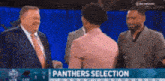 a man in a suit and tie is talking to a woman in a pink shirt on a television screen that says panthers selection