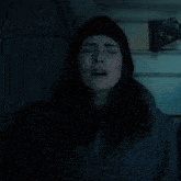 a woman with her eyes closed wearing a beanie
