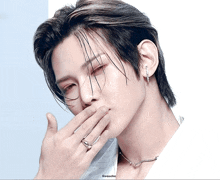 a close up of a man covering his mouth with his hand with a watermark that says gouache