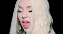 a woman with blonde hair is singing into a microphone .
