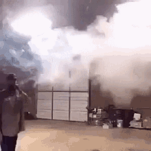 a man is standing in front of a building that is on fire .