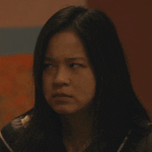 a close up of a woman 's face with a serious look