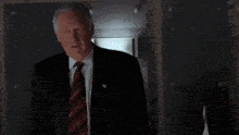 a man in a suit and tie is standing in the dark