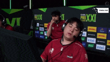 a man wearing headphones stands in front of a wall that says pro xxi league
