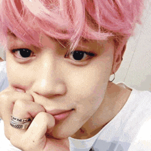 a man with pink hair has a ring on his finger