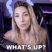 a woman sitting in front of a microphone with the words what 's up written below her