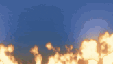 a blue sky with flames in the foreground and a few clouds in the background