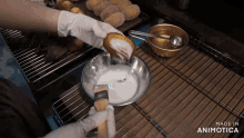 a person is dipping a donut in a bowl that says made in animatica on the bottom