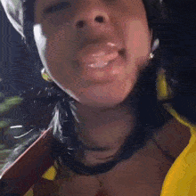 a close up of a woman wearing a yellow shirt