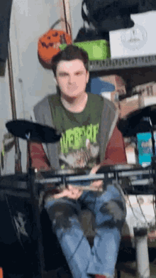 a man wearing a green shirt that says ' overkill ' on it is playing drums