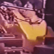 a blurred image of a person in a yellow shirt