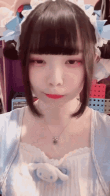 a girl wearing a blue and white dress with a necklace