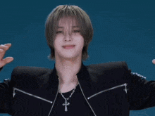 a man in a black jacket with a cross necklace