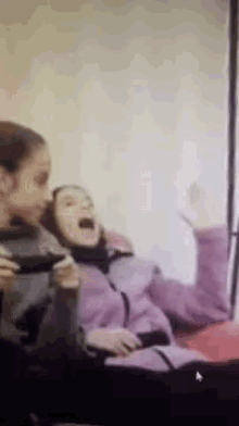 a couple of girls sitting next to each other with one yawning