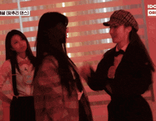 three women are standing next to each other in front of a sign that says ido