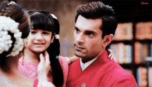 a man in a red suit is holding a little girl in his arms