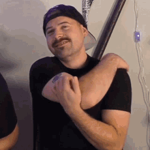 a man with a mustache is holding another man 's elbow