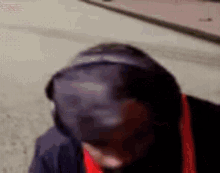 a man wearing a hooded jacket and a hat is standing on a sidewalk .
