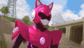 a pink robot with a cat 's head and ears is standing on a sidewalk .