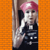 a woman wearing a pink hat and a black shirt with the number 11 on it