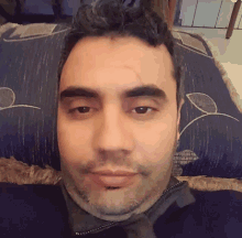 a man with a beard is laying on a blue blanket