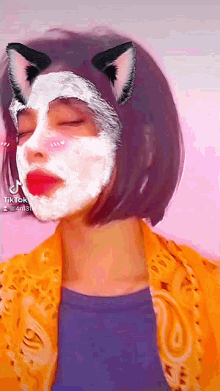 a girl with a cat ear mask on her face has tiktok written at the bottom