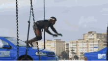 a man is jumping over a blue car that says challenge on it