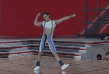 a man is dancing on a stage with his arms outstretched