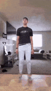a man standing in a living room wearing a t-shirt that says off