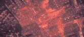 an aerial view of a city on fire with a lot of fire coming out of it .