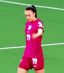 a woman in a pink jersey with the number 19 on it