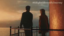 a man and a woman are standing on a balcony overlooking the ocean with the hashtag #abigbold beautiful journey