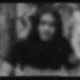 a black and white photo of a person with a blurred background