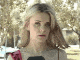 a close up of a woman 's face with a microphone in her hand