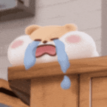a stuffed animal is crying with tears coming out of its eyes and mouth .