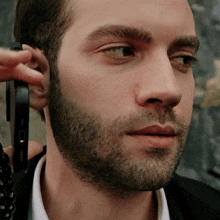 a close up of a man 's face with a phone in his ear