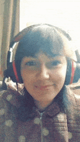 a girl wearing headphones looks at the camera and smiles
