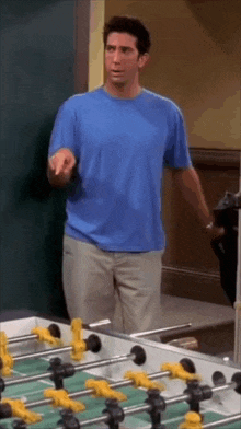 a man is standing in front of a foosball table .