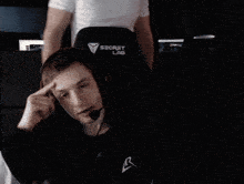 a man wearing headphones and a microphone is sitting in a gaming chair .