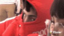 a man wearing a red hoodie with the word flixier on the bottom right