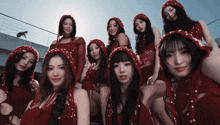 a group of young women wearing red hooded dresses pose for a picture