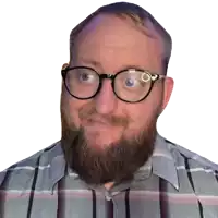 a man with glasses and a beard is smiling