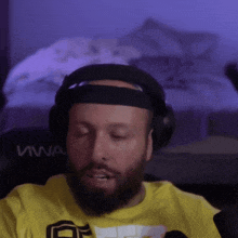 a man with a beard wearing headphones and a yellow shirt with the word viva on it